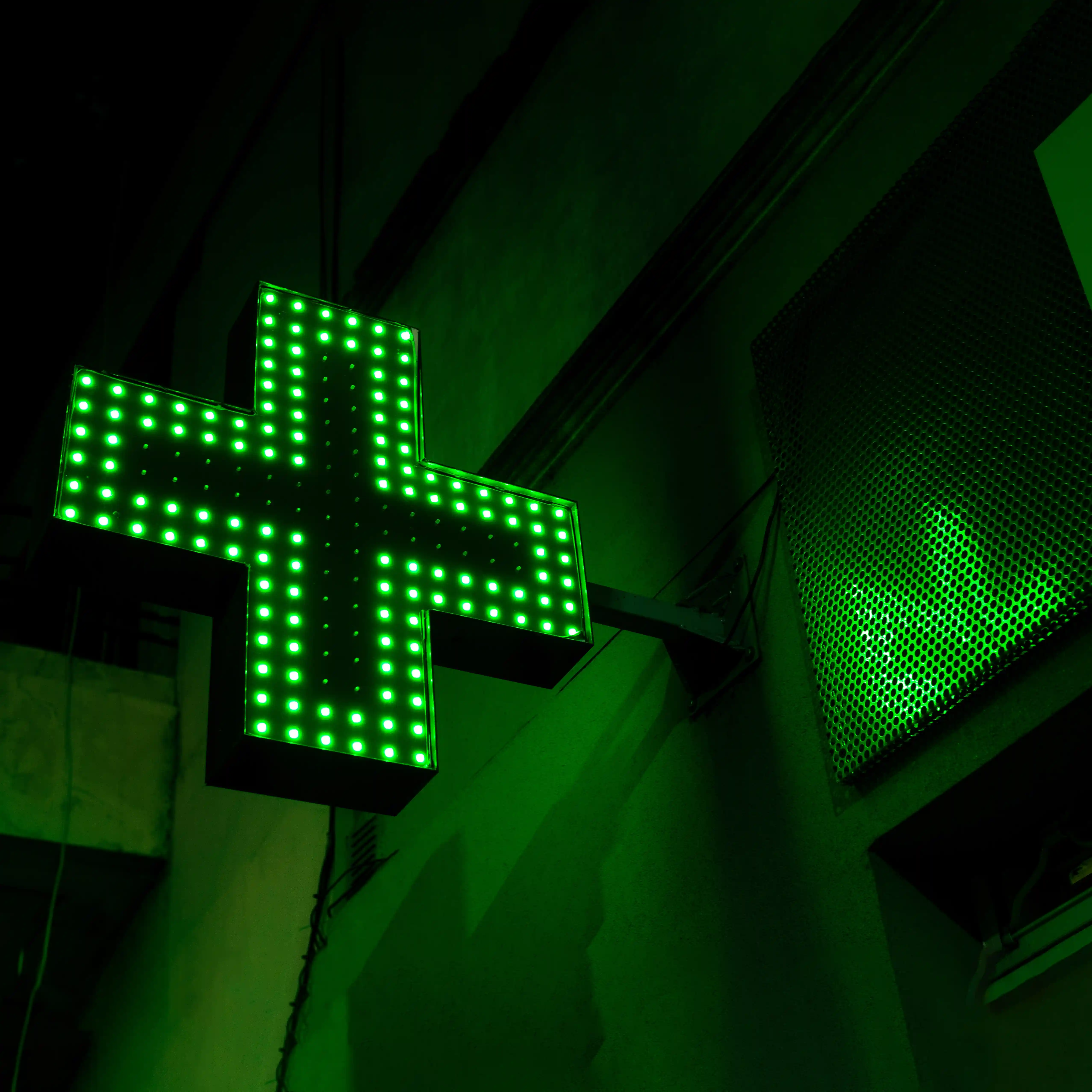 A neon green pharmacy sign